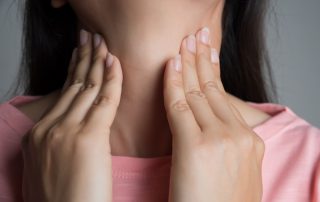 a woman touching her neck as though it is painful