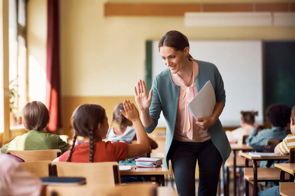 Happy,Elementary,School,Teacher,Giving,High-five,To,Her,Student,During Food allergies require educating those around the child