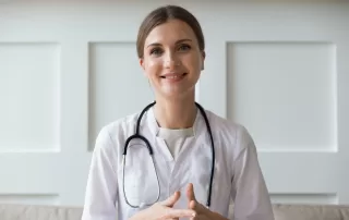 A guide to choosing a telehealth doctor, woman in white lab coat smiling