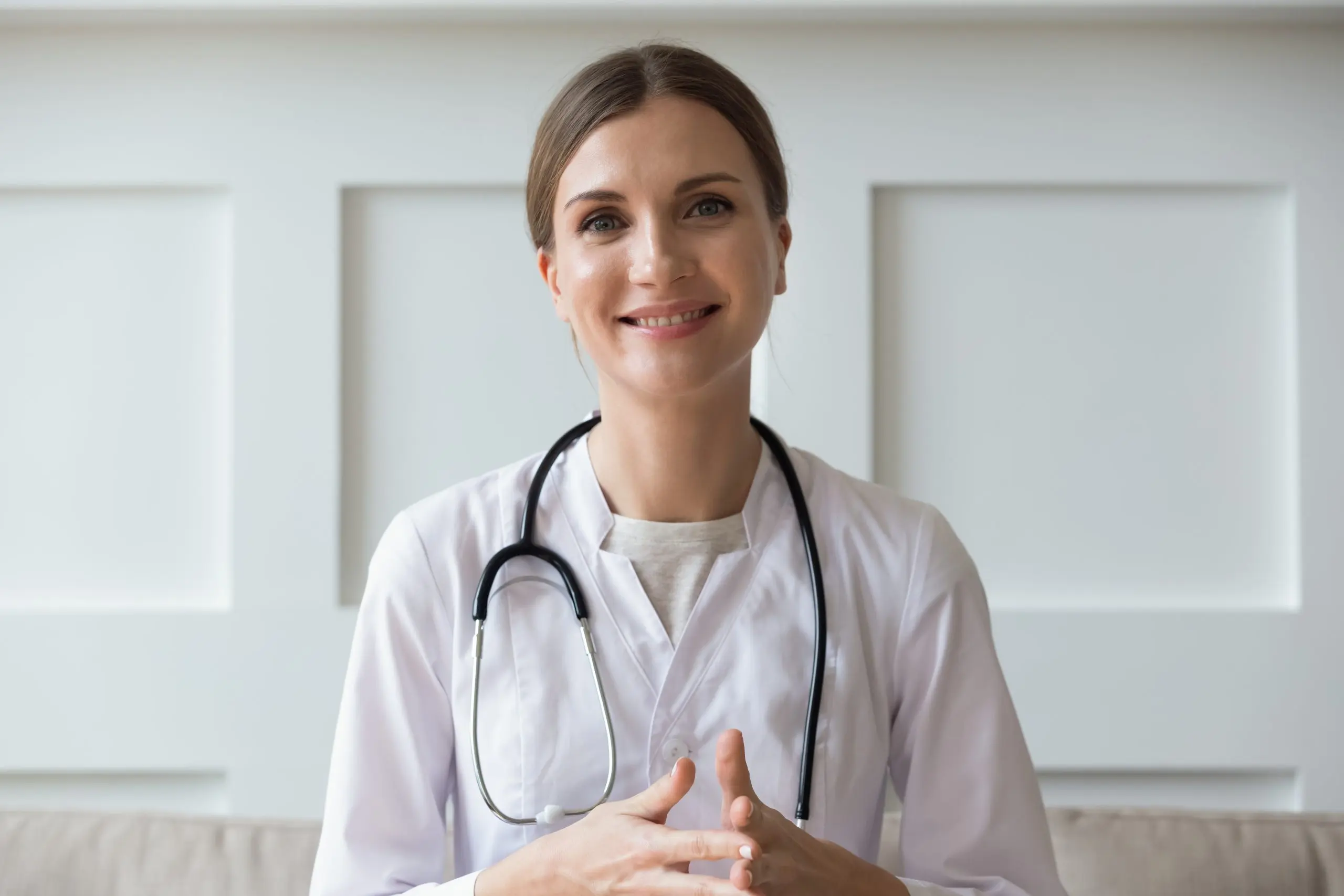 A guide to choosing a telehealth doctor, woman in white lab coat smiling