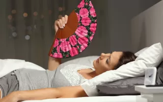 Woman lying in bed drenched in perspiration experiencing night sweats