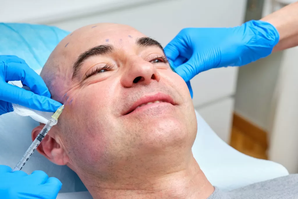 Smiling mature man getting anti-wrinkle treatment on his face with botulinum toxin Smiling mature man getting anti-wrinkle treatment on his face with botulinum toxin
