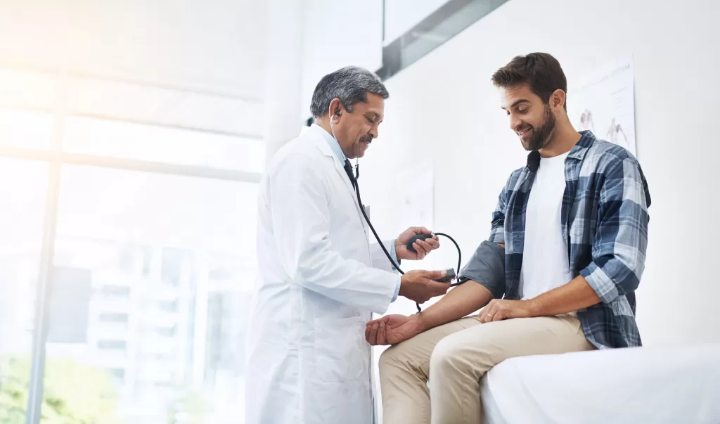 Man-in-doctors-office-consulting-medical-professional-scaled Man in doctors office consulting medical professional