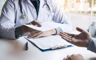 doctor handing a medical certificate to a patient