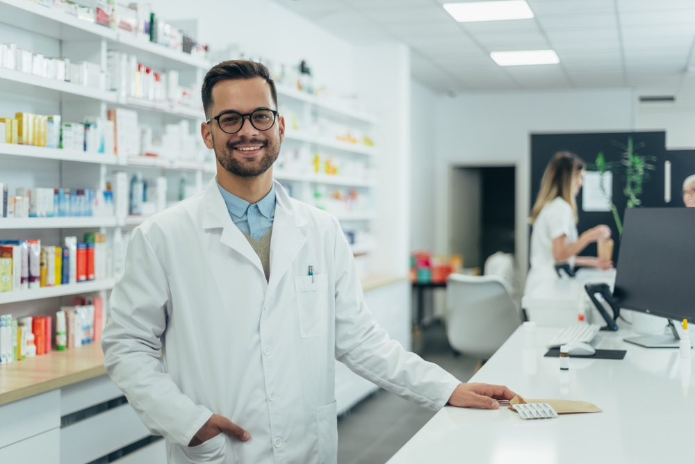 a smiling male pharmacist in the dispensary